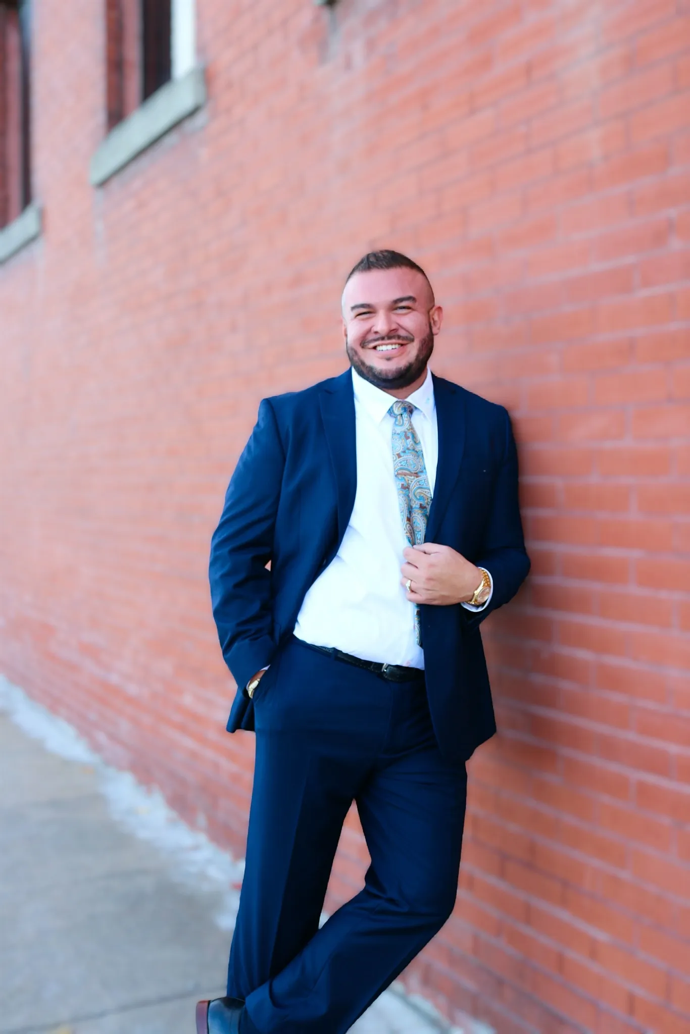 A picture of Anthony Moreno, the owner of MorenoLawKC leaning against a brick wall in Kansas City, Missouri.